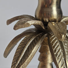 Close-up van een gouden kandelaar in de vorm van een palmboom. 