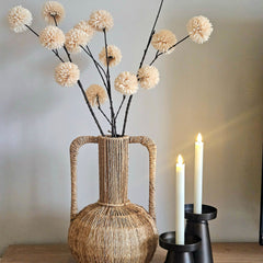 Kunstbloem chrysanthemum pompom crème - bolbloemen en zachte tinten op een een vaas met rieten en handvaten. Er staan twee prachtige en verschillende hoogtes bruine kandelaren naast.