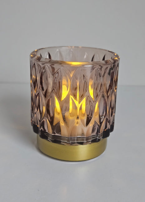 Close-up van waxinelichthouder roze glas - gouden voet en elegante afwerking