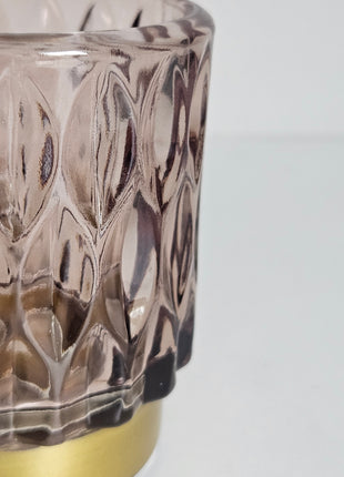 Close-up van waxinelichthouder roze glas met gouden voet - romantische gloed