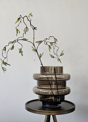 Vaas Disk donkerbruin glas gepresenteerd op dressoir met droogbloemen