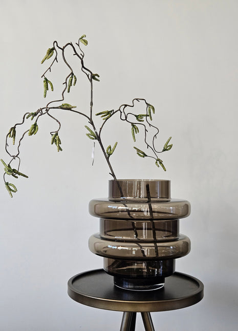 Vaas Disk donkerbruin glas gepresenteerd op dressoir met droogbloemen