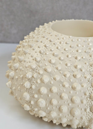 Waxinelichthouder Sea Urchin crème met natuurlijke textuur op dressoir