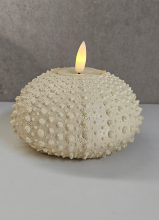 Waxinelichthouder Sea Urchin crème gepresenteerd op dienblad met kaarslicht