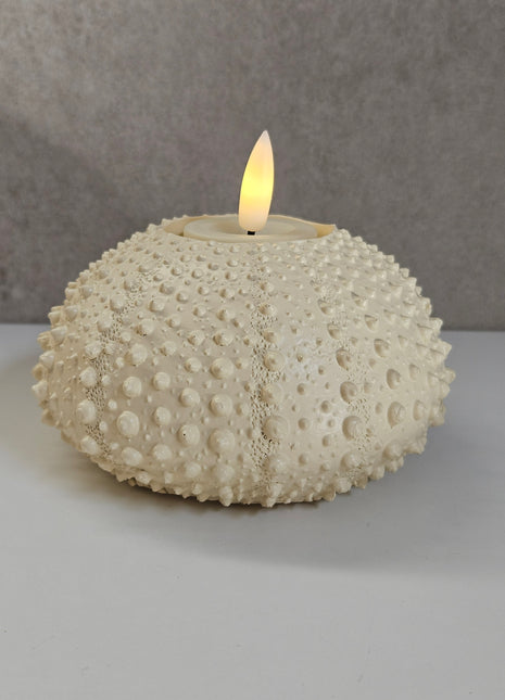 Waxinelichthouder Sea Urchin crème gepresenteerd op dienblad met kaarslicht