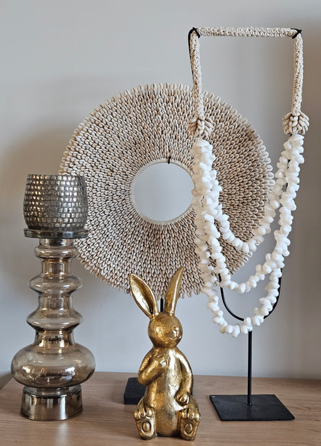 Ornament Chilandy goud gepresenteerd op dressoir met decoratieve accessoires