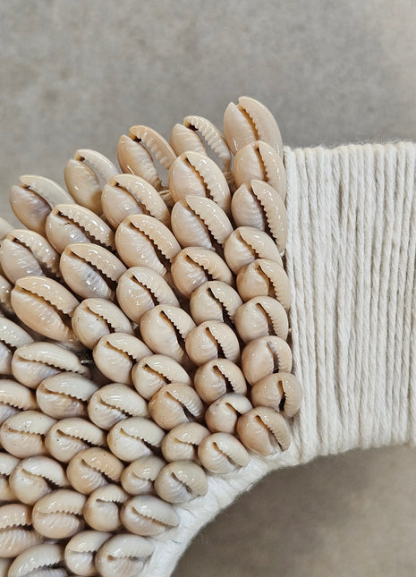 Schelpenketting wit gepresenteerd op dressoir met decoratieve accessoires