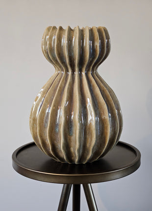 Groene keramieken vaas Lenn met een organische ribbelvorm en glanzende afwerking, 29,5 cm hoog, gepresenteerd op bijzet tafel.