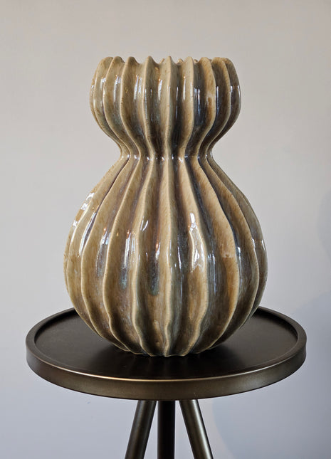 Groene keramieken vaas Lenn met een organische ribbelvorm en glanzende afwerking, 29,5 cm hoog, gepresenteerd op bijzet tafel.