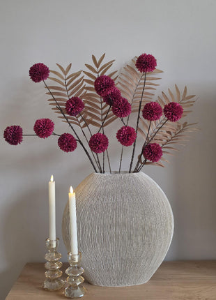 Vooraanzicht van burgundy-bruin Autumn Burgundy kunstboeket met stoffen bloemen in geribbelde vaas naast kaarsen