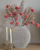 Vooraanzicht van roze-bruin Soft Blush & Bronze kunstboeket met stoffen bloemen in geribbelde vaas naast kaarsen