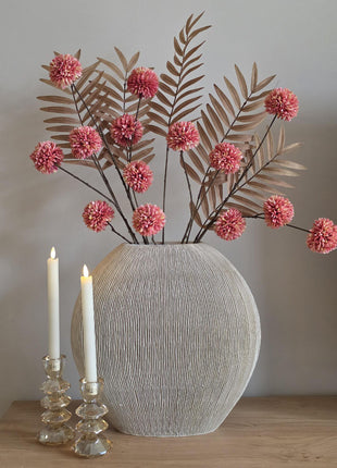 Vooraanzicht van roze-bruin Soft Blush & Bronze kunstboeket met stoffen bloemen in geribbelde vaas naast kaarsen