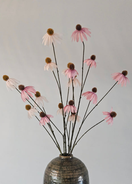 Een boeket oud roze en witte kunst-Echinacea zonnehoeden gepresenteerd in een vaas.