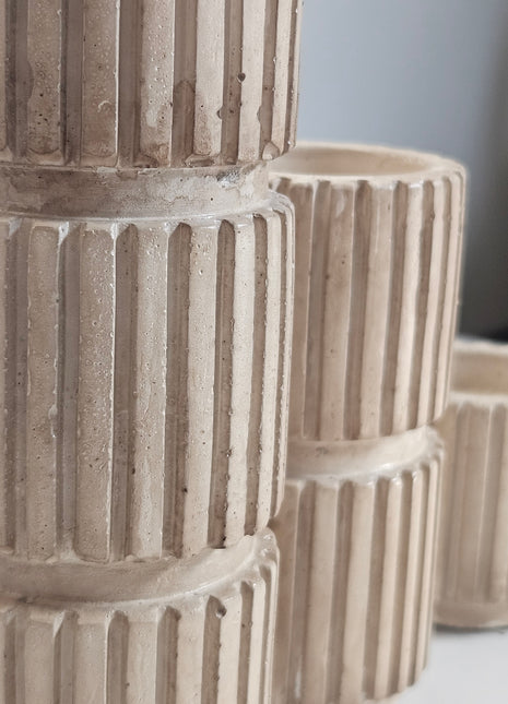 Close-up van kandelaren ribbel beige keramiek - verschillende hoogtes en organische vorm