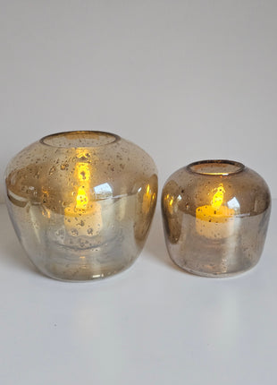 Waxinelichthouders Capira bruin grijs glas gepresenteerd op dienblad met warme ambiance