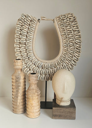 Houten kandelaar lichtbruin gepresenteerd op dressoir met kaars en decoratie