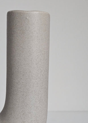 Close-up van vaas U vorm grijs aardewerk - sculpturale vorm en natuurlijke tinten