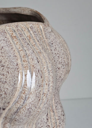 Close-up van vaas organisch zand aardewerk - sculpturale vorm en natuurlijke tinten
