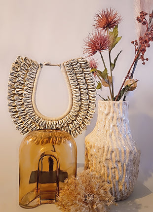 Vaas amber bruin glas gepresenteerd op dressoir met droogbloemen