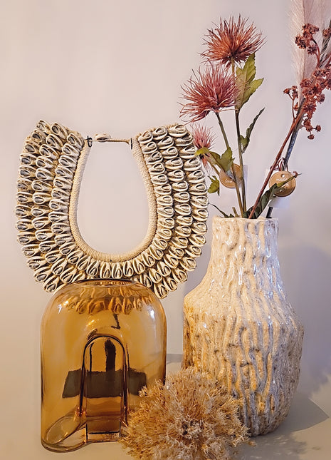 Vaas amber bruin glas gepresenteerd op dressoir met droogbloemen