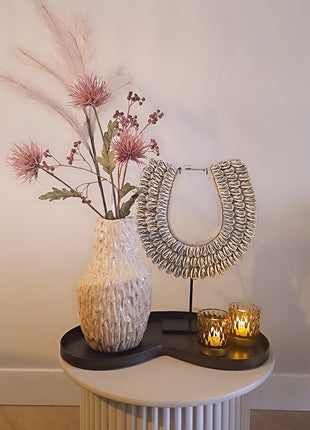 Waxinelichthouder roze glas gepresenteerd op dressoir met kaarslicht