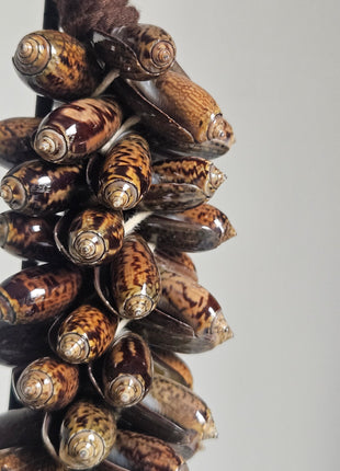 Close-up van schelpenketting natuurlijk - gevlochten band en warme tinten