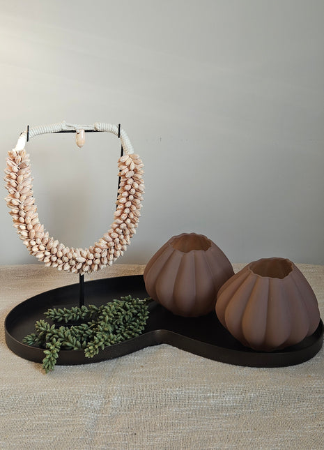 Vaas ribbeltextuur bruin glas gepresenteerd op tafel met decoratie