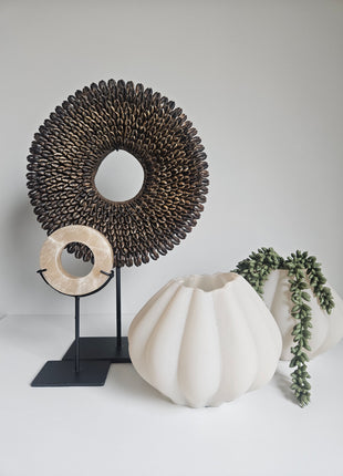 Vaas ribbeltextuur beige glas gepresenteerd op vensterbank