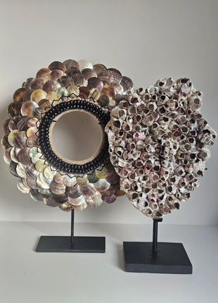 Ornementen schelpenketting en zeepokken gepresenteerd als decoratieve woonaccessoires.