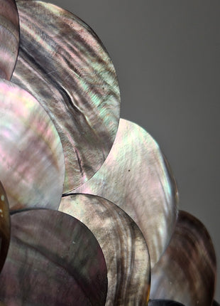 Close-up van schelpenketting met rondgepolijste schelpen en zwarte kralen - handgemaakt