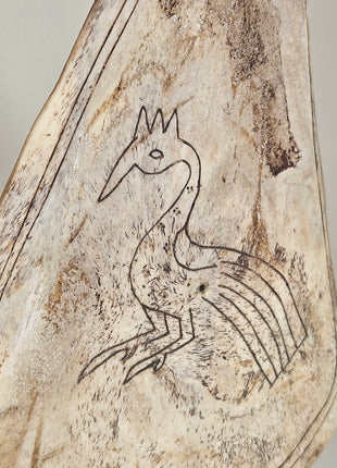 Close-up van ornament lepel met pauw - handgesneden details en natuurlijke afwerking