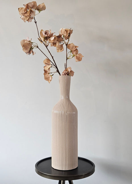 Geribbelde aardewerk vaas Conic M in beige met een smalle hals en brede schouder op een houten ondergrond
