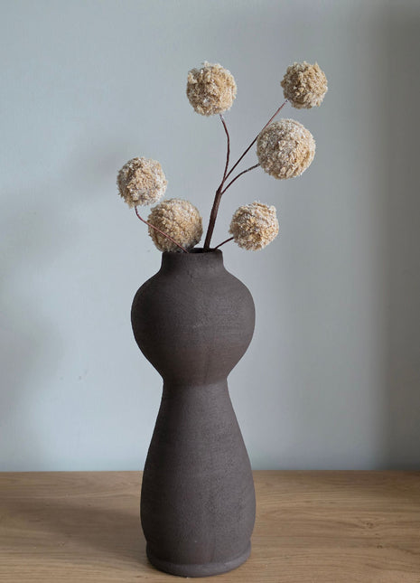 Vooraanzicht van bruin-creme Fluffy Snowballs kunsttak met glitterbollen in een donkerbruine vaas op hout