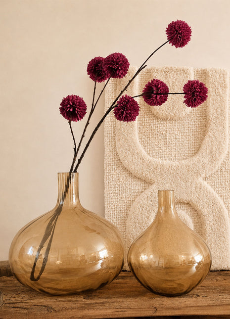 Glazen vazen bruin amber glanzend L en M naast elkaar op een houten dressoir met bordeauxrode pompom zijdetakken en een crème wandpaneel