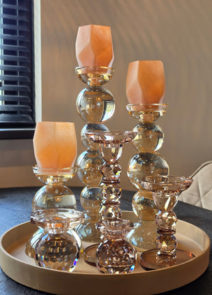 Kandelaar Alouette goud kristalglas S in een warme interieurset op een donker houten tafel met brandende kaarsen
