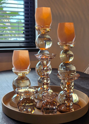 Kandelaar Opulent in bruin kristalglas in een decoratieset met roze kaarsen op een donker houten tafel