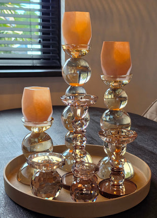 Kandelaar Opulent in bruin kristalglas in een interieurset op een dienblad met brandende kaarsen
