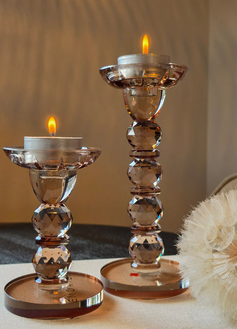 Kandelaar Opulent in bruin kristalglas maten M en S met brandende waxinelichtjes op een tafelkleed