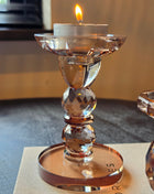 Kandelaar Opulent S van Colmore in bruin kristalglas met gefacetteerde bolvorm op een donker houten oppervlak