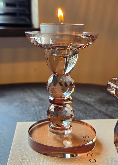 Kandelaar Opulent S van Colmore in bruin kristalglas met gefacetteerde bolvorm op een donker houten oppervlak