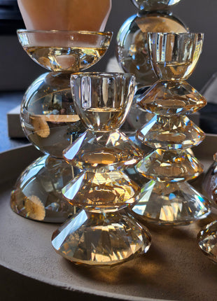 Close-up van de gefacetteerde diamantvormige schijven van kandelaar Rovelo in amber kristalglas