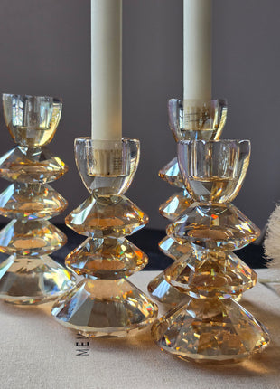 Set van vier kandelaars Rovelo van Light & Living in amber kristalglas in verschillende maten op een donker houten tafel