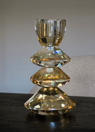 Kandelaar Rovelo M in amber kristalglas van Light & Living op een donker houten oppervlak