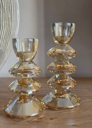 Kandelaar Rovelo in amber kristalglas in een set met andere woonaccessoires op een houten tafel