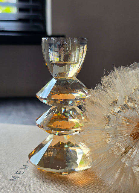 Kandelaar Rovelo S van Light & Living in amber kristalglas op een donker houten oppervlak