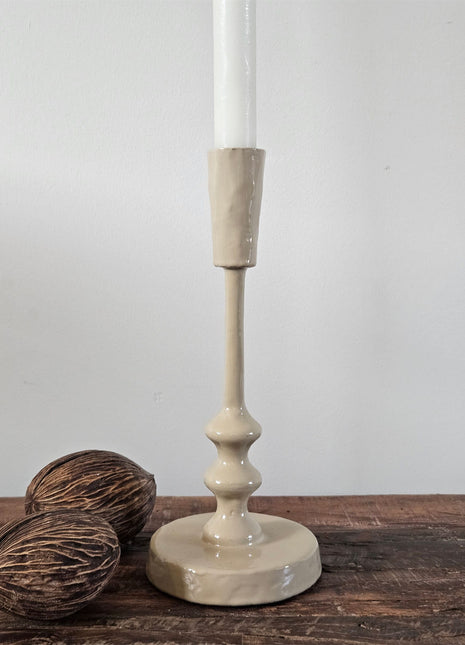 Geglazuurde ijzeren kandelaar Sand M in zand-beige met een gedraaide stijl en ronde voet met een witte dinerkaars op een houten ondergrond