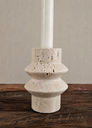Close-up van een kandelaar steen beige-grijs met een gevlekte steenstructuur en een ronde schijfvorm