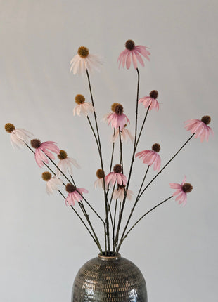 Een boeket oud roze en witte kunst-Echinacea zonnehoeden gepresenteerd in een vaas.