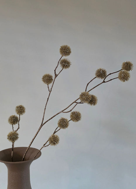 Vooraanzicht van champagnekleurige Echinops kunsttakken met glitter op stekelige bollen in een taupe halsvaas
