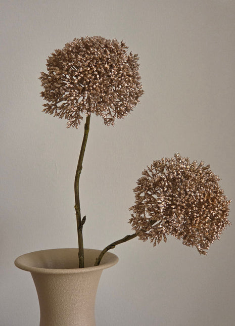 Vooraanzicht van goudkleurige Eupatorium kunsttakken met glanzende bloemschermen in een creme halsvaas